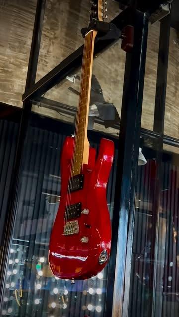 Guitarra eléctrica roja colgada en el salón