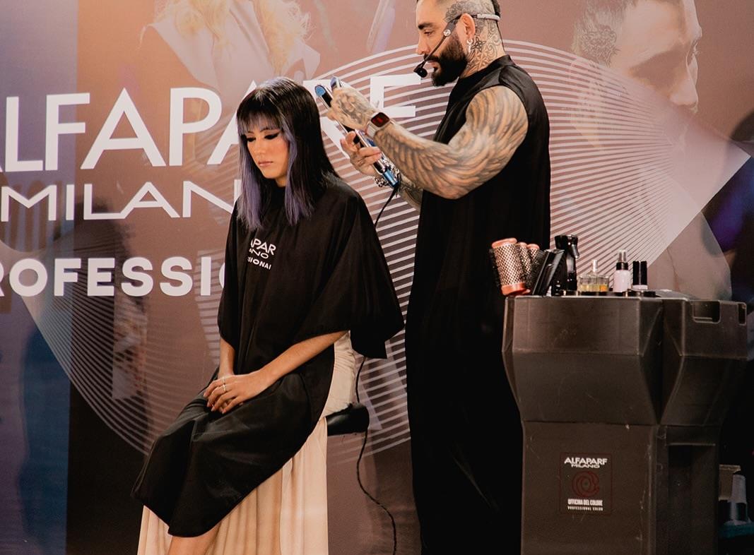 Julián Pérez peinando a una modelo en el escenario de Alfaparf Milano
