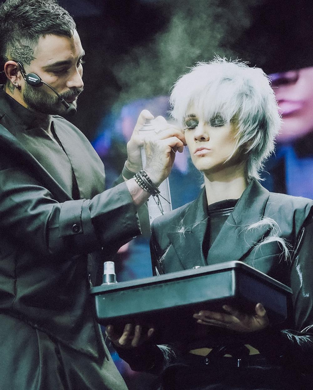 Estilista retocando a una modelo de cabello blanco sobre el escenario